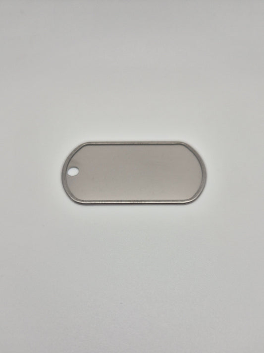 Back side, with a rolled edge, of an aluminum, military id-style dog tag on a light background