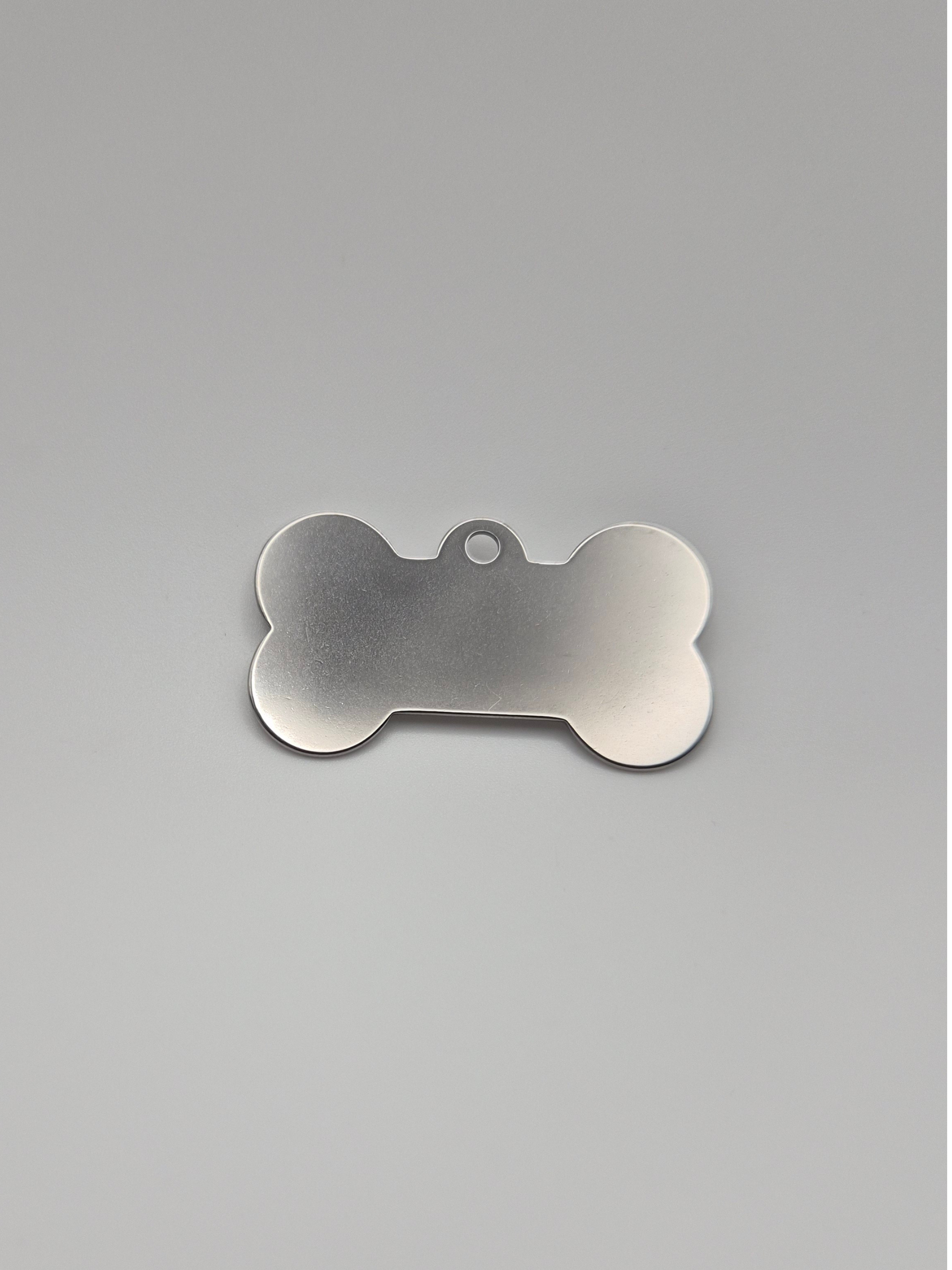 Stainless steel bone-shaped dog tag on a light background