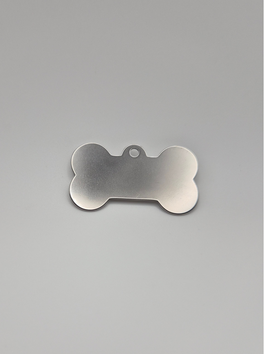 Stainless steel bone-shaped dog tag on a light background