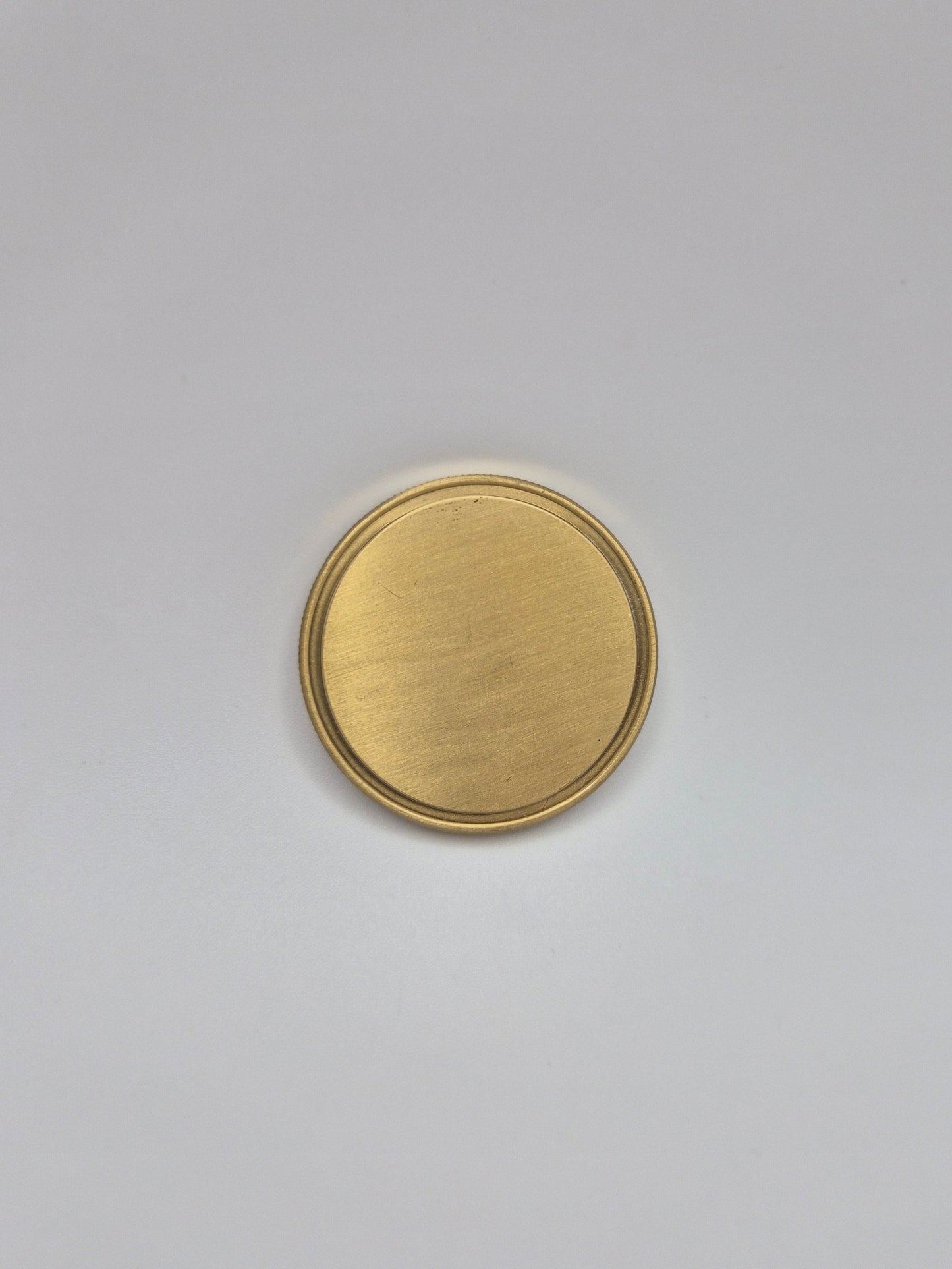Gold, blank commemorative coin on a light background