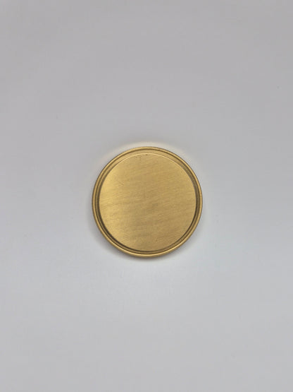 Gold, blank commemorative coin on a light background