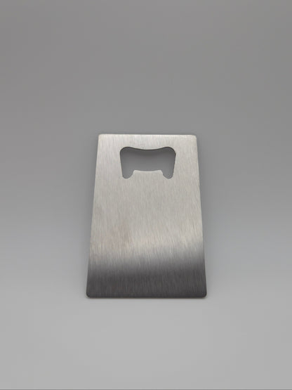 Brushed stainless steel, credit card-sized bottle opener on a light background
