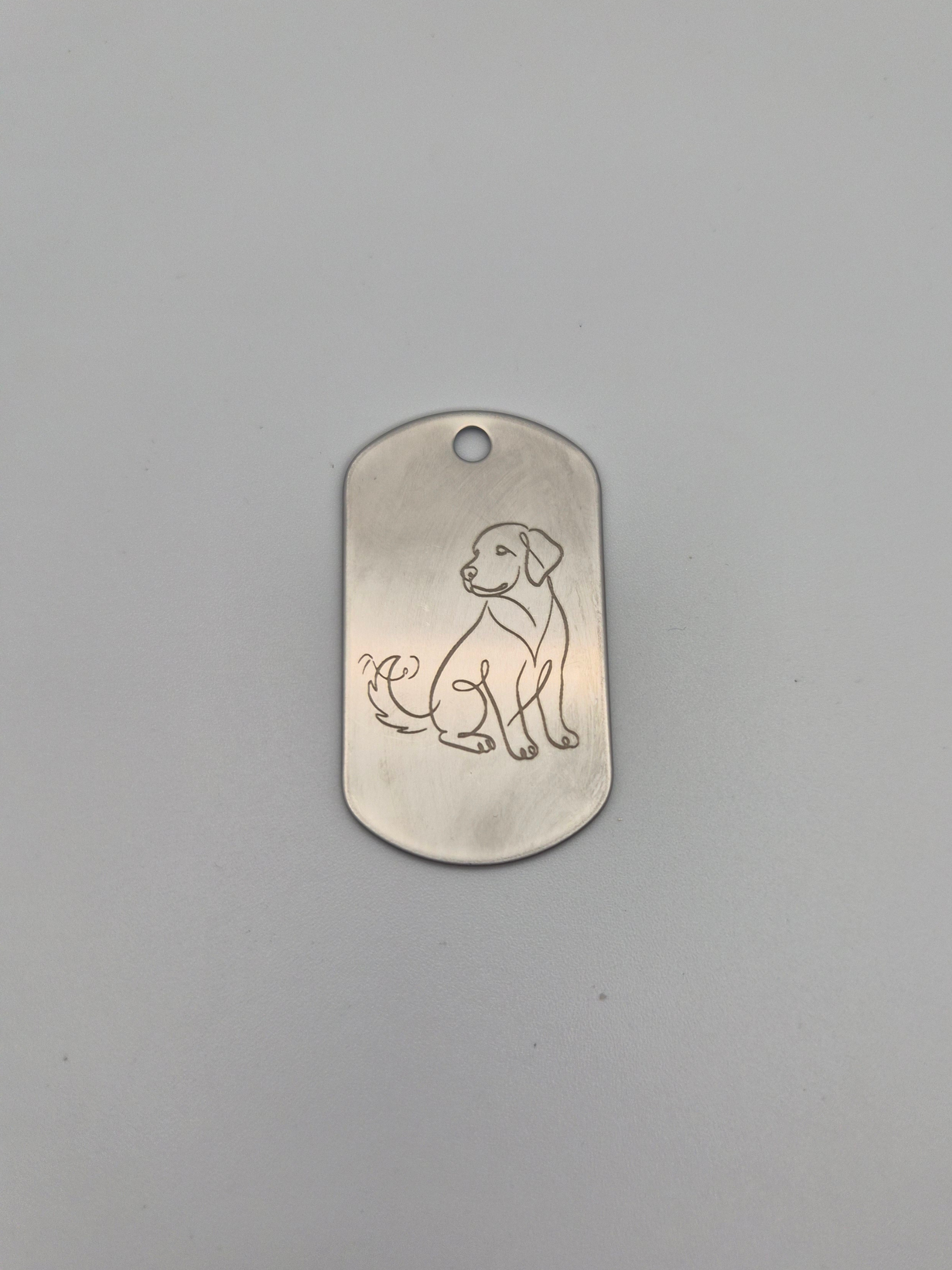 Aluminum military ID-style dog tag with an engraved dog design on a gray background