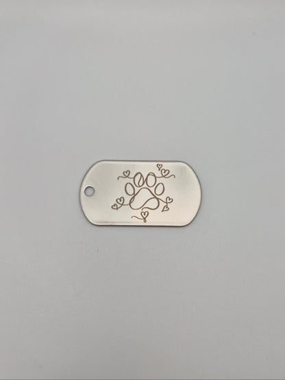 Aluminum, military ID-style dog tag with engraved paw & hearts design on a gray background