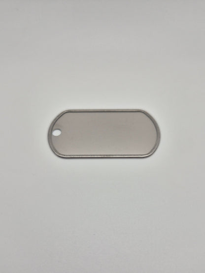 Back side, with a rolled edge, of an aluminum, military id-style dog tag on a light background