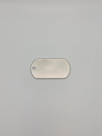 Front, smooth side of an aluminum, military id-style dog tag on a light background