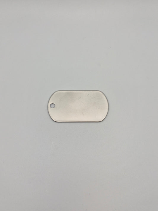 Front, smooth side of an aluminum, military id-style dog tag on a light background