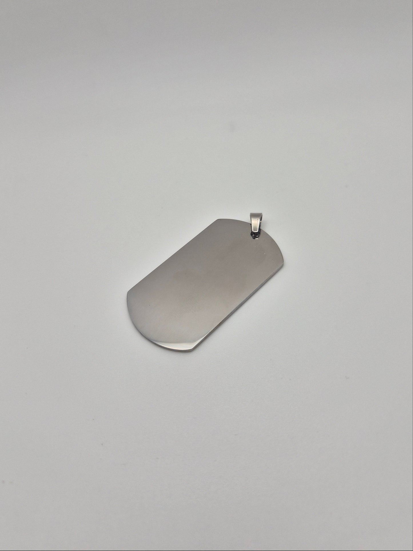 Smooth, stainless steel, military id-style dog tag on a light background