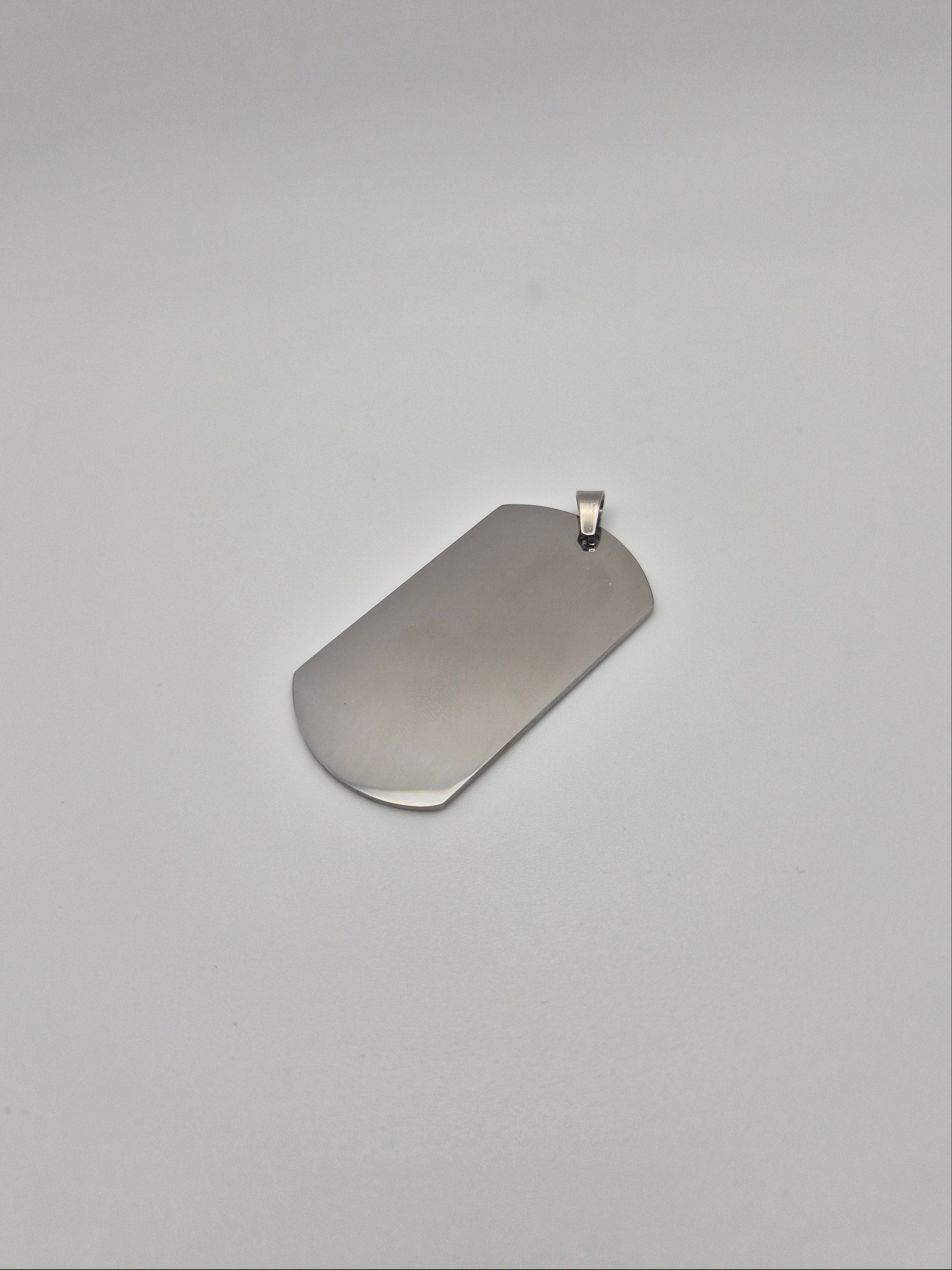 Smooth, stainless steel, military id-style dog tag on a light background