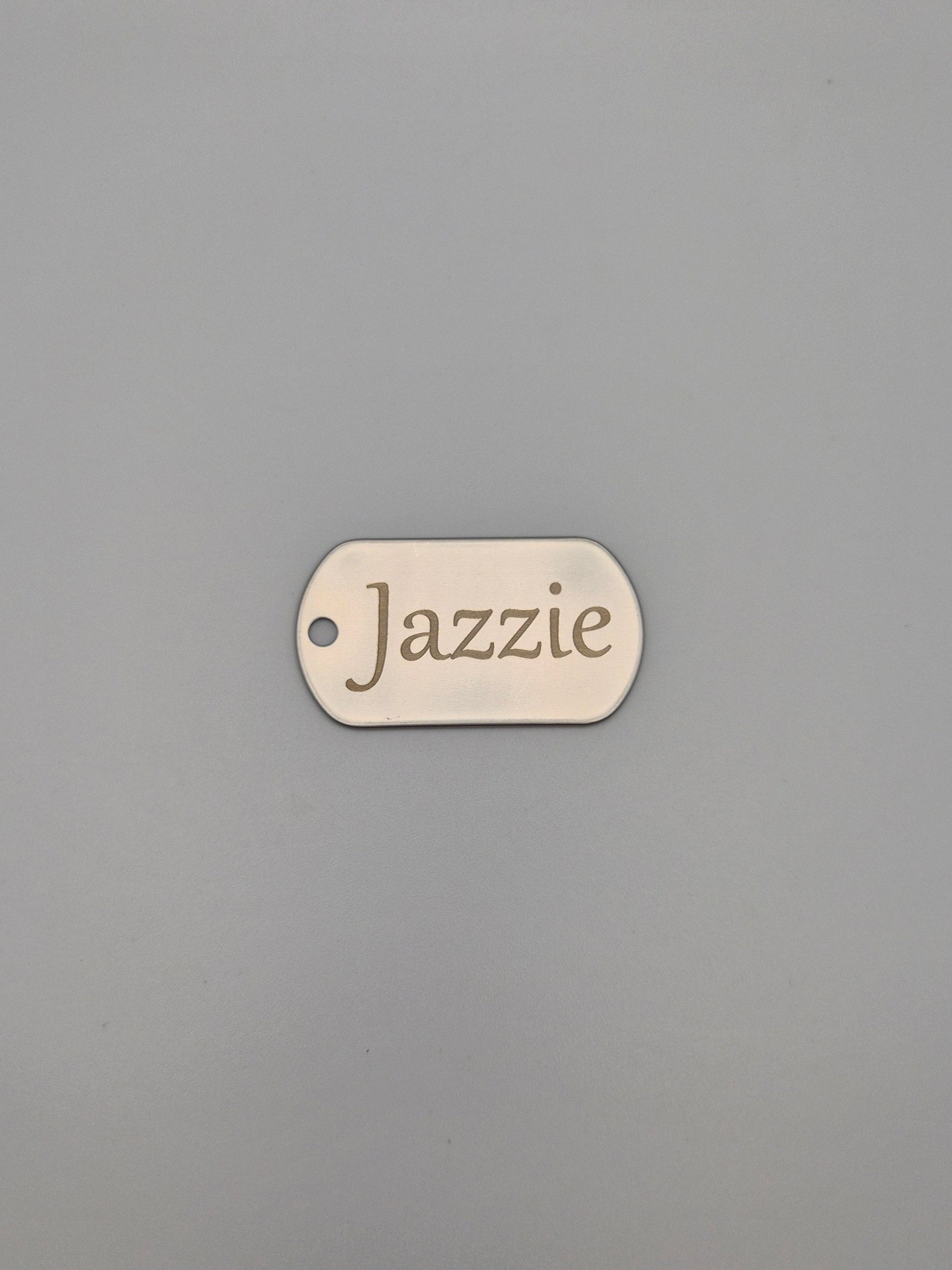 Aluminum, military ID-style dog tag with 'Jazzie' engraved on a gray background