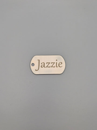Aluminum, military ID-style dog tag with 'Jazzie' engraved on a gray background