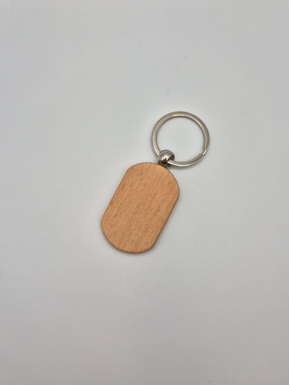 Oval, wooden keychain with metal ring sitting on a light gray background